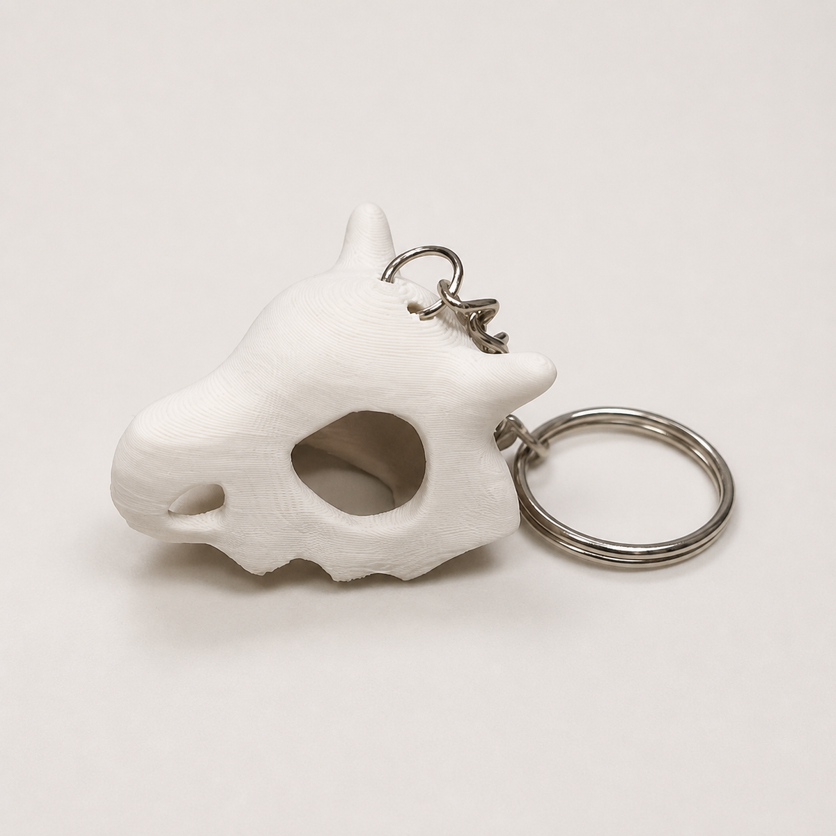 Llavero con cráneo de Cubone impreso en 3D en PLA Bone White con anilla metálica